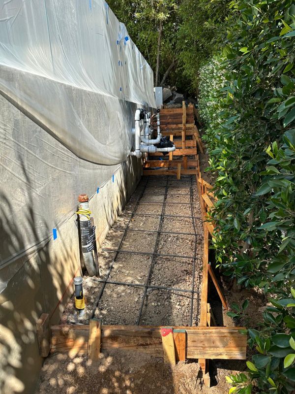 Rebar grid and wood forms for a side-yard walkway on a gravel base