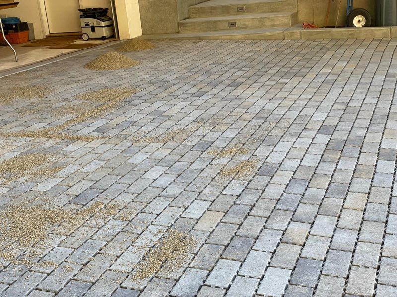Close view of tumbled gray and tan pavers with joint sand