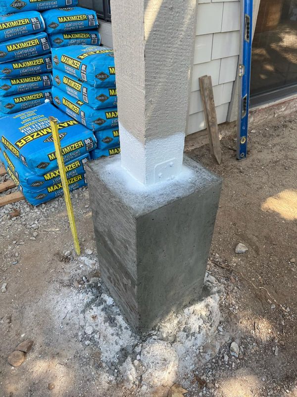 Fresh concrete pier poured around the base of a pergola post