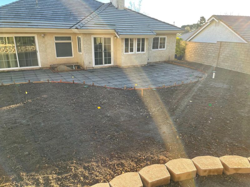 Rebar grid over a compacted base inside curved wood forms, before the pour