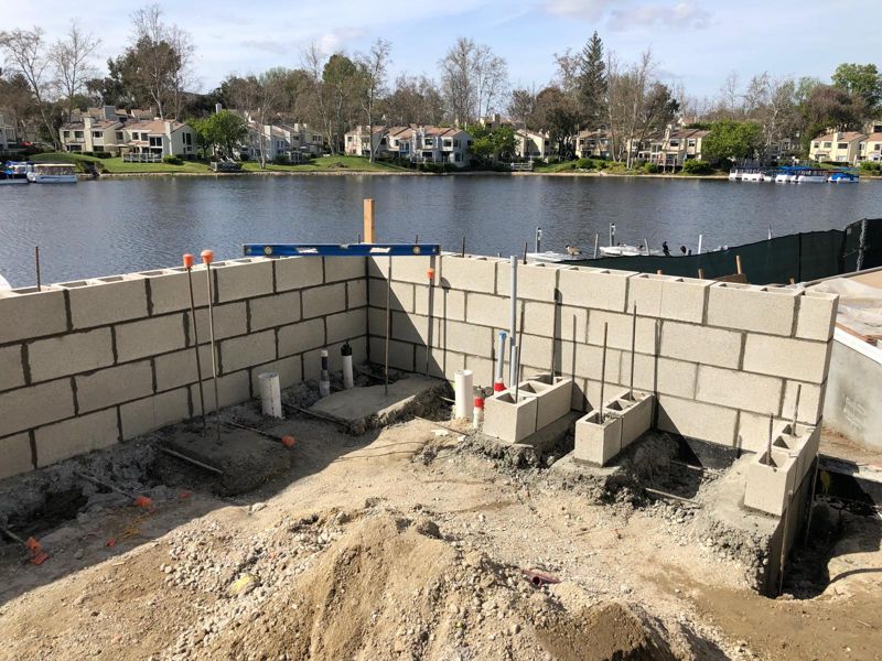 Concrete block walls for an outdoor kitchen under construction beside the lake
