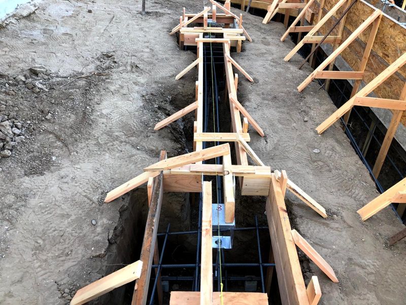 Footing trench with a rebar cage, wood forms and a string line